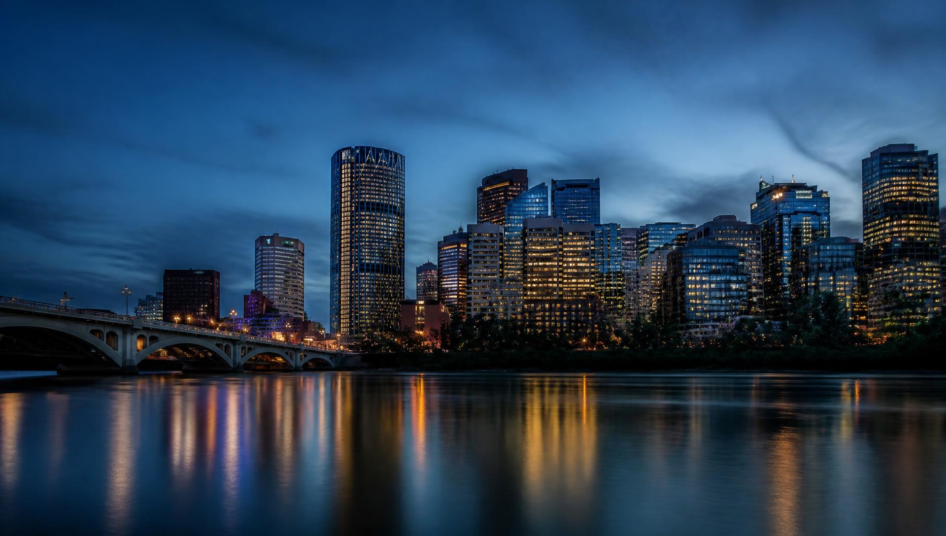 Calgary skyline at blue hour across the Bow River